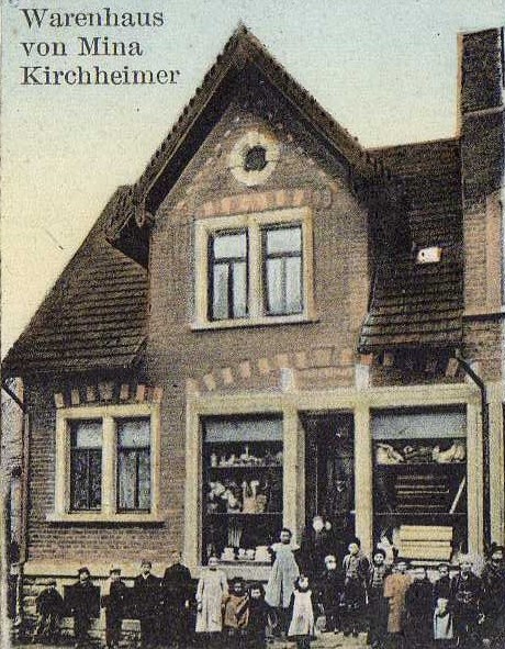  Das Warenhaus von Mina Kirchheimer auf einer Ansichtskarte anfangs des 20. Jahrhunderts. Davor stehen viele Kinder und Erwachsene. - Das Bild wird mit Klick vergrößert 