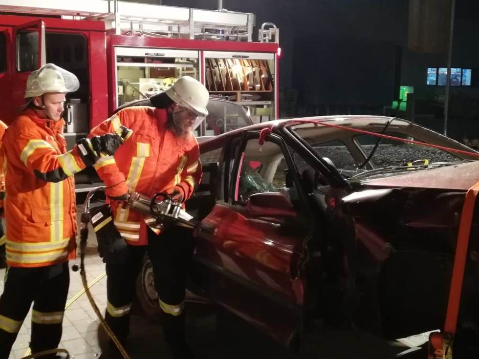  2 Feuerwehrmänner beim Öffnen einer Autotür mit dem Spreizer - das Bild wird mit Klick vergrößert 